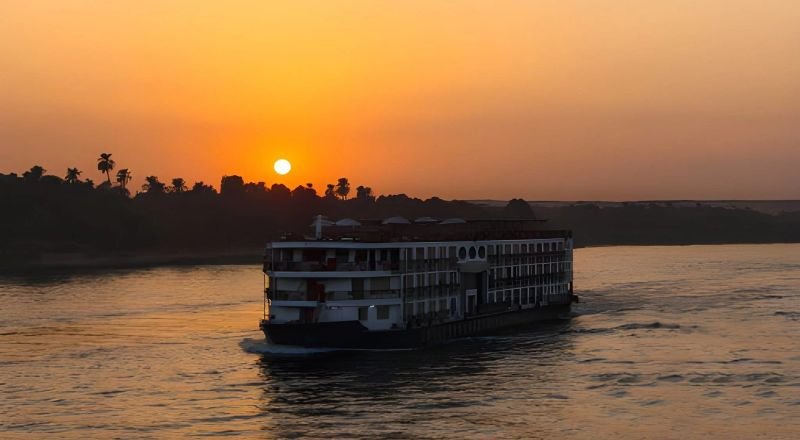 Barco de crucero navegando por el Nilo al atardecer