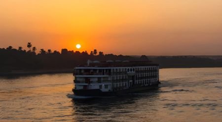 Barco de crucero navegando por el Nilo al atardecer